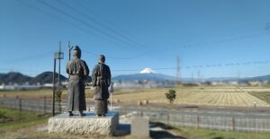 蛭ヶ小島の、富士山を向く源頼朝と北条政子の像（静岡県伊豆の国市）